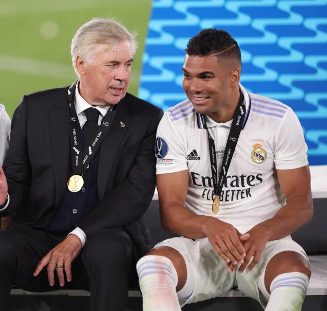 Real Madrid players Eder Militao and Casemiro with coach Carlo Ancelotti after winning the UEFA Super Cup.