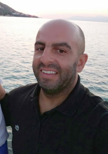 Samir Zitouni, a staff member of London North Eastern Railway, smiling by the sea.