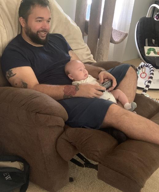 Devaughn Debelak holding his son Leo Debelak on his lap.