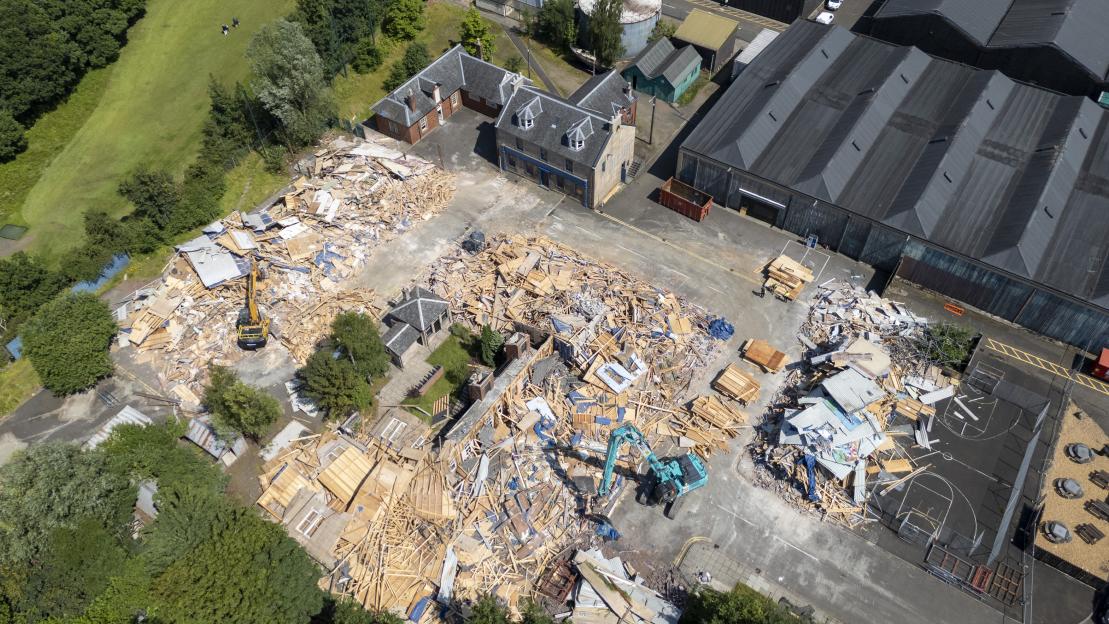 Aerial view of the demolition of the River City studio set, showing bulldozers amidst piles of debris.