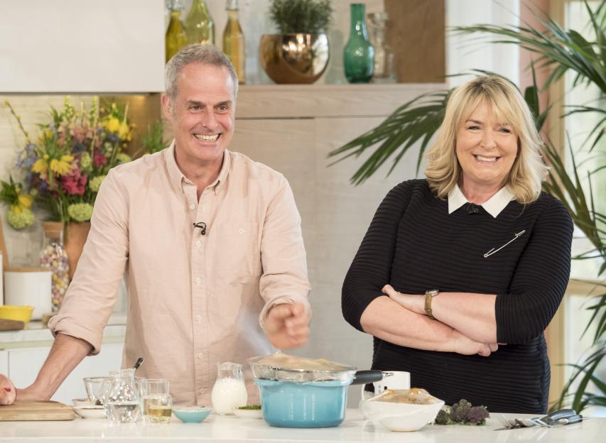 Phil Vickery and Fern Britton smiling while filming the TV show 'This Morning'.