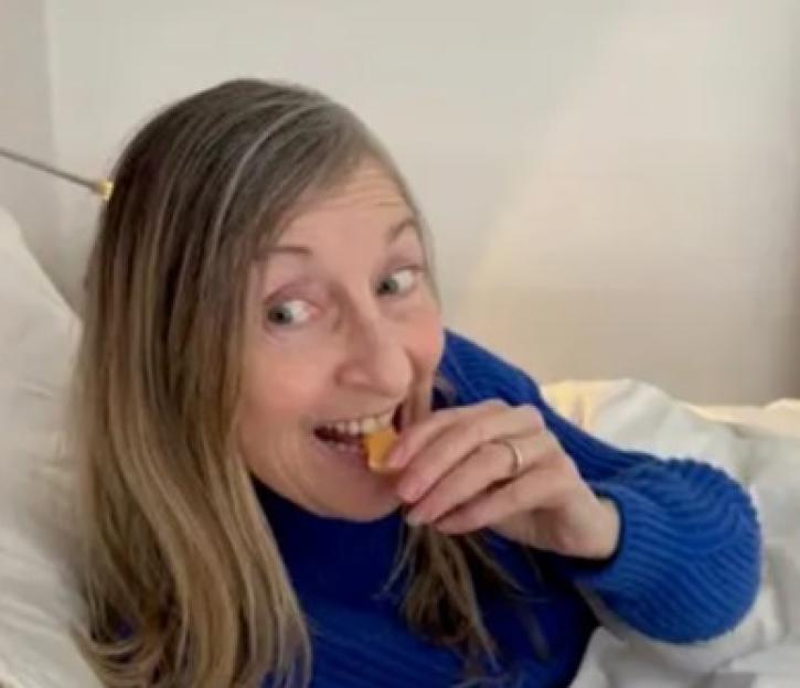 Fiona Phillips eating while lying in bed.