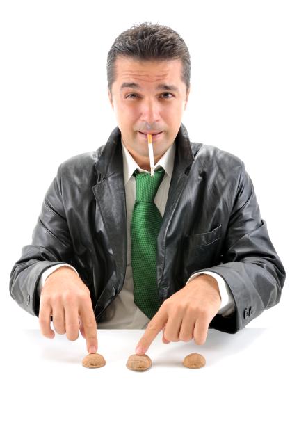 A smoking con man performing a shell game with cups on a white background.