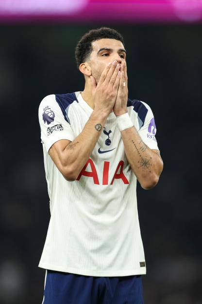 Tottenham Hotspur player Japhet Tanganga covers his mouth with his hands, looking upset.