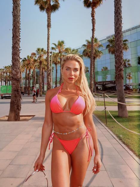 Gabby Allen in a two-piece bikini in Spain, showing off her abs.