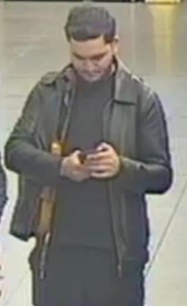 CCTV images of two men, one looking at a phone, the other wearing a cap and beard.