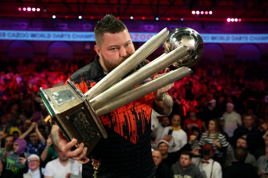 Michael Smith kisses the Cazoo World Darts Championship trophy.