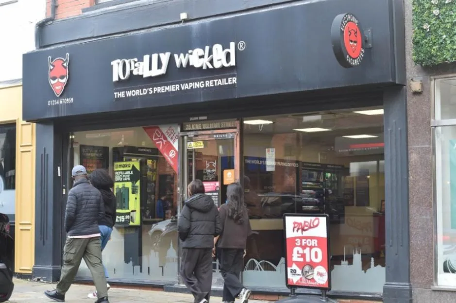 Exterior view of a Totally Wicked vaping retailer shopfront, with several people walking past and looking into the store.