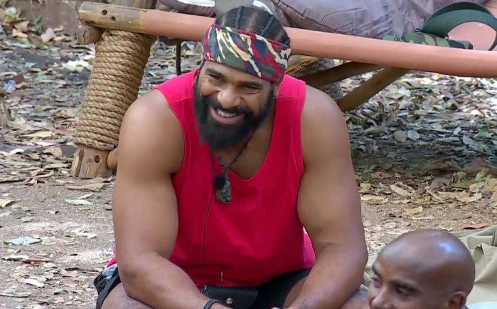 David Haye laughing while wearing a red vest and a camouflage bandana.