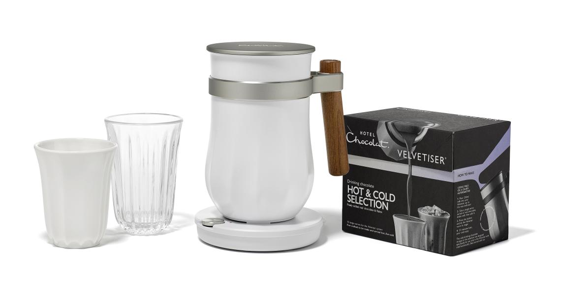 A Hotel Chocolat Velvetiser hot chocolate machine, two glasses, and a box of Hotel Chocolat drinking chocolate.
