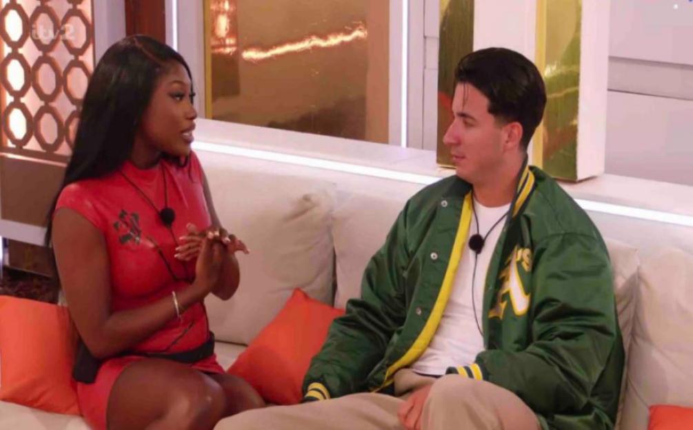 Tommy and Leanne from Love Island talking on a couch.