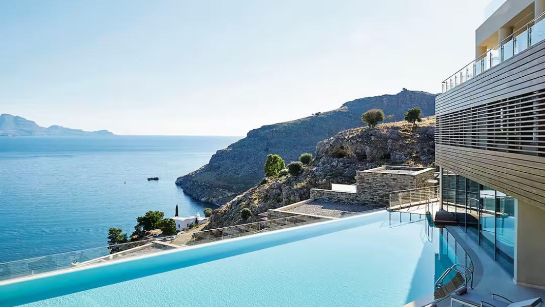 Infinity pool overlooking the ocean and a rocky coastline.