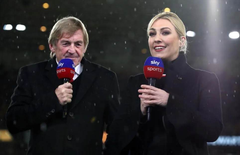 Sky Sports presenter Kelly Cates and Sir Kenny Dalglish holding Sky Sports microphones in front of a match.