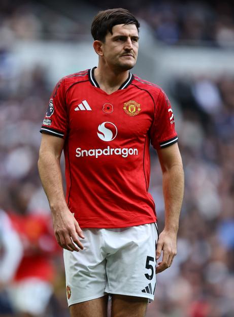 Manchester United player Harry Maguire in his red team jersey and white shorts.
