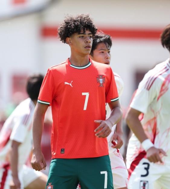 Cristiano Junior playing soccer in a red and green uniform against Japan.