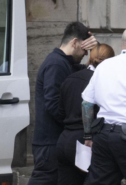 Rapualla Ahmadze, 21, being led away by law enforcement after being sentenced to nine years imprisonment for rape.