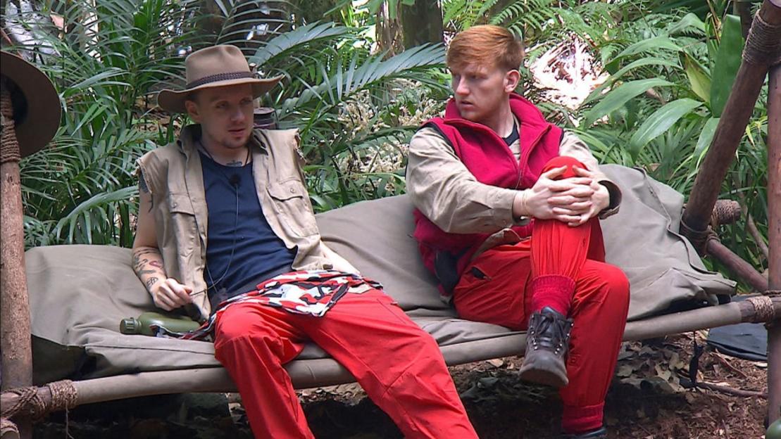 Two male celebrities in jungle attire on "I'm a Celebrity... Get Me Out of Here!"