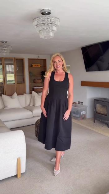 Josie Gibson in a black dress showcasing the results of arm surgery.