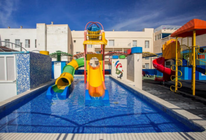Colorful waterpark with slides and a swimming pool.