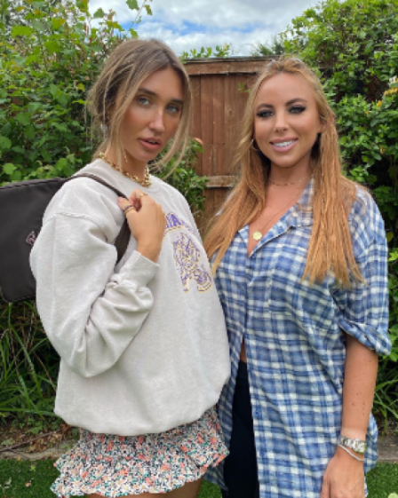 Two women posing in a garden.