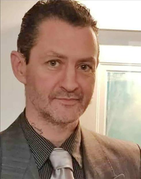 Daniel Coleman, an alleged murderer, wearing a striped shirt and light-colored tie.