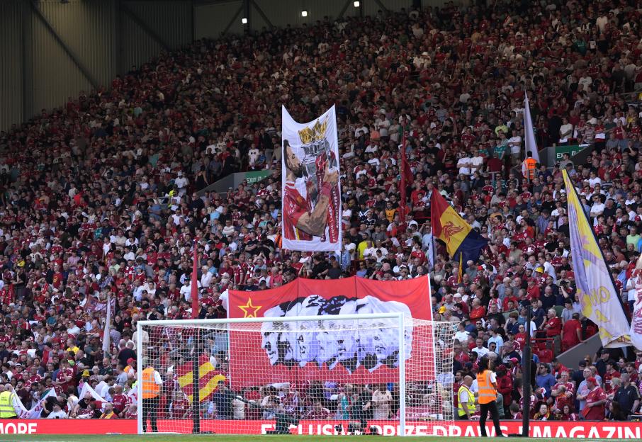 Fans in the stands at a football match hold up a banner of Mohamed Salah.