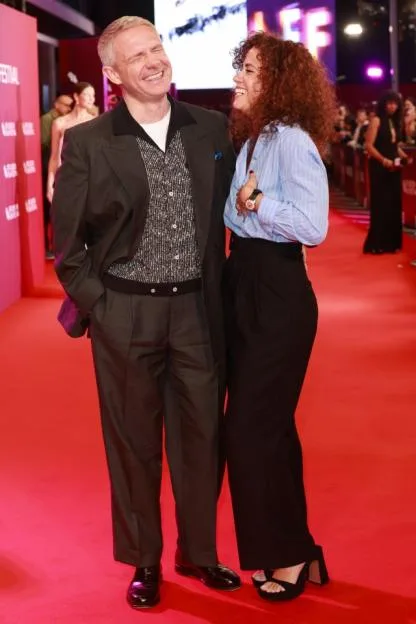 Martin Freeman and Rachel Benaissa smiling and posing on the red carpet.