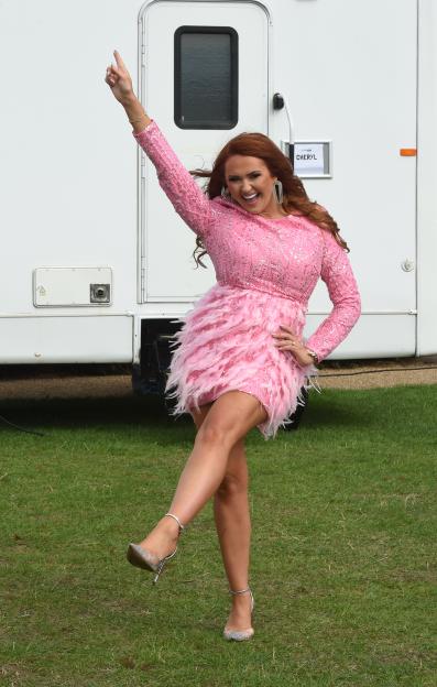 Charlotte Dawson striking a pose in a pink feathered and sequined dress.