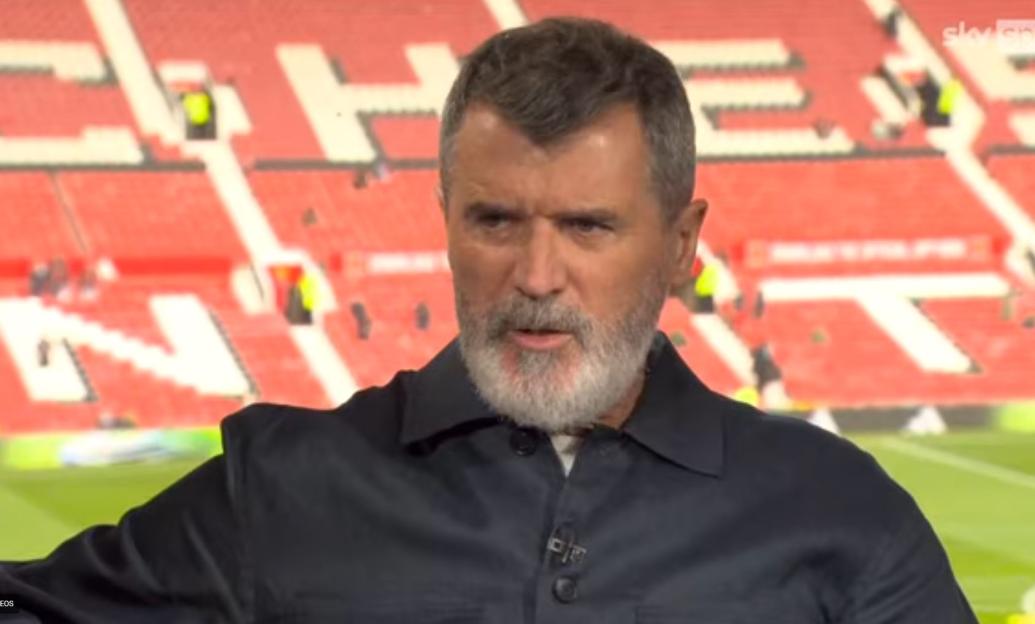 Roy Keane wearing a dark shirt in front of a stadium background, speaking intently.