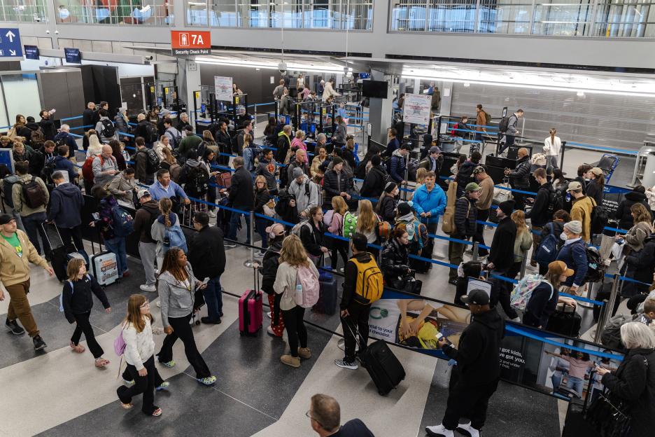 Travelers waiting in a long line at a security checkpoint in Terminal 3 of O'Hare International Airport.
