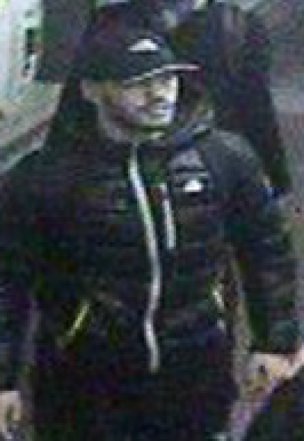 A man wearing a black baseball cap and a dark puffer jacket.