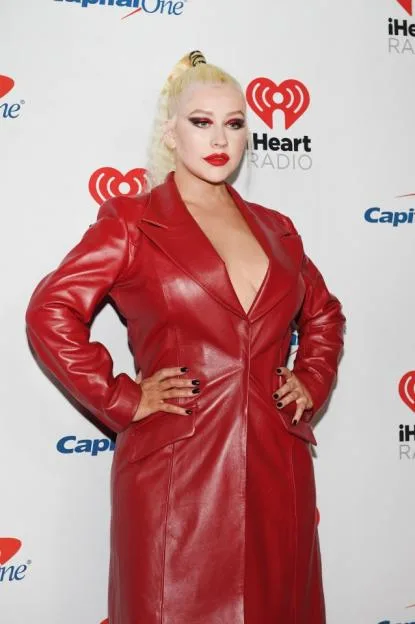 Christina Aguilera in a red leather trench coat at the iHeartRadio Music Festival.