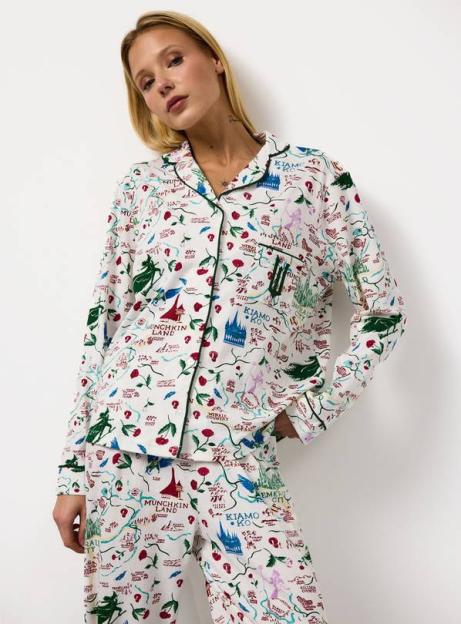 Model wearing white Wicked pyjamas patterned with a map of Oz, including Munchkinland and Emerald City.
