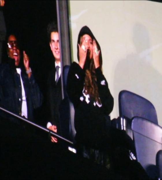 Beyoncé smiling and covering her eyes while Jay-Z and a crowd sing "Happy Birthday" at Tottenham Hotspur Stadium.