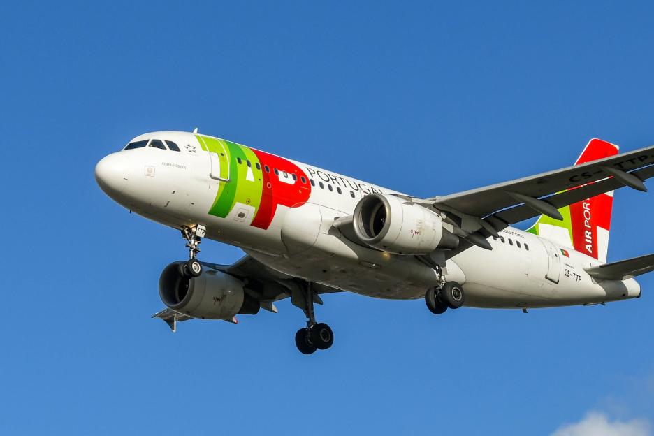 Airbus A319 jet operated by Portuguese airline TAP against a blue sky