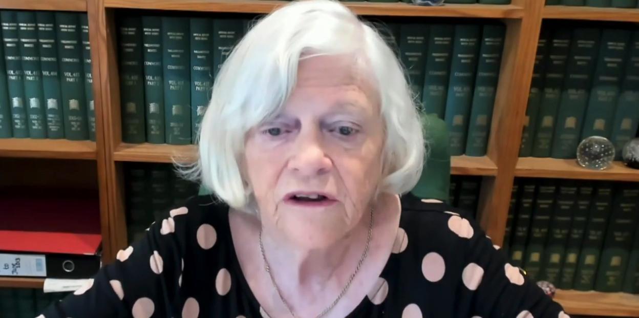 Ann Widdecombe being interviewed, with bookshelves filled with legal texts in the background.