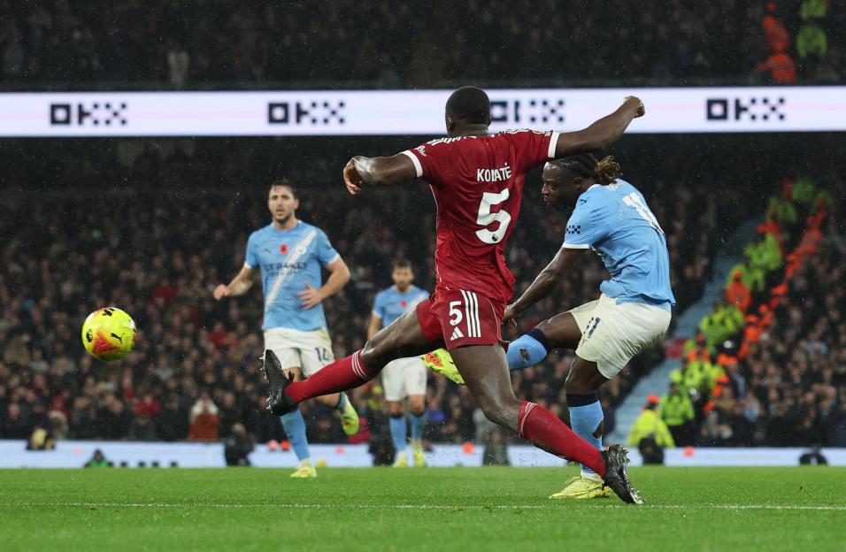 Jeremy Doku of Manchester City scores a goal against Liverpool.