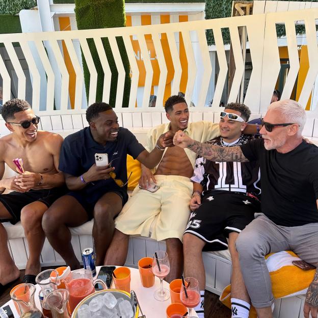 Jude Bellingham, Jobe Bellingham, and Wayne Lineker, along with two other men, laughing and fist-bumping.