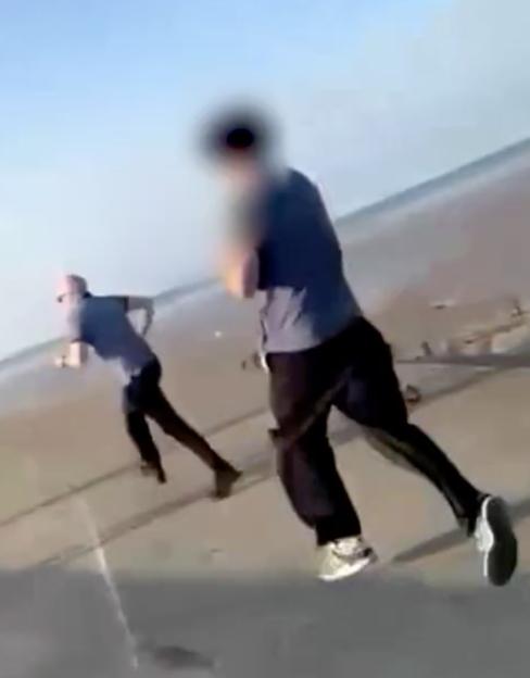 Two blurred figures running on a beach.