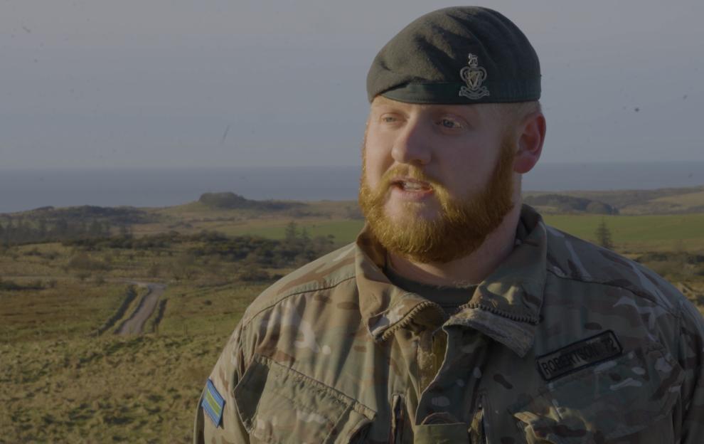 Cpl. Bradley Robertson in military uniform, speaking outdoors.