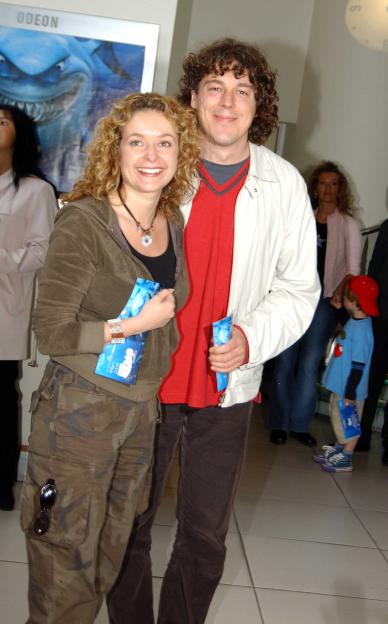 Two actors smiling and holding "Finding Nemo" flyers at the film's UK premiere.