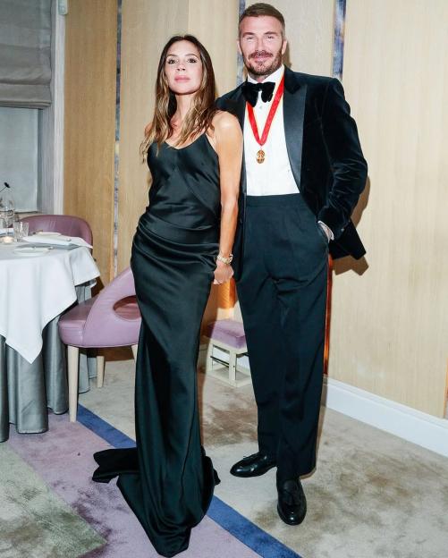 Victoria and David Beckham posing together at a party celebrating his knighthood.