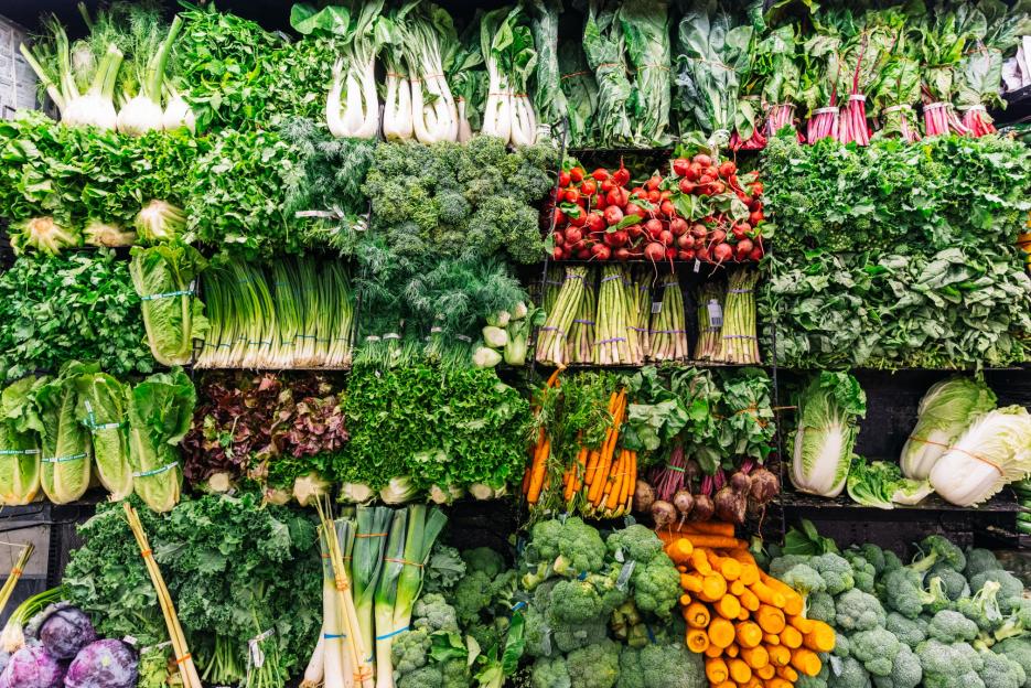 Fresh greens and vegetables displayed in a supermarket.