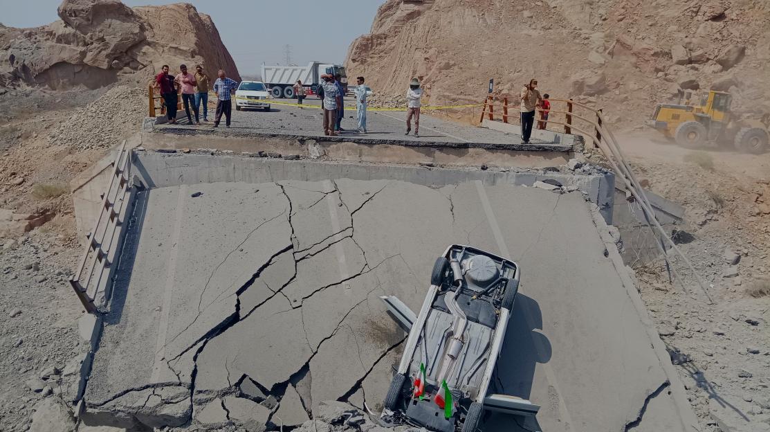 An overturned car on a destroyed bridge section after a strike in Hormozgan province, southern Iran.