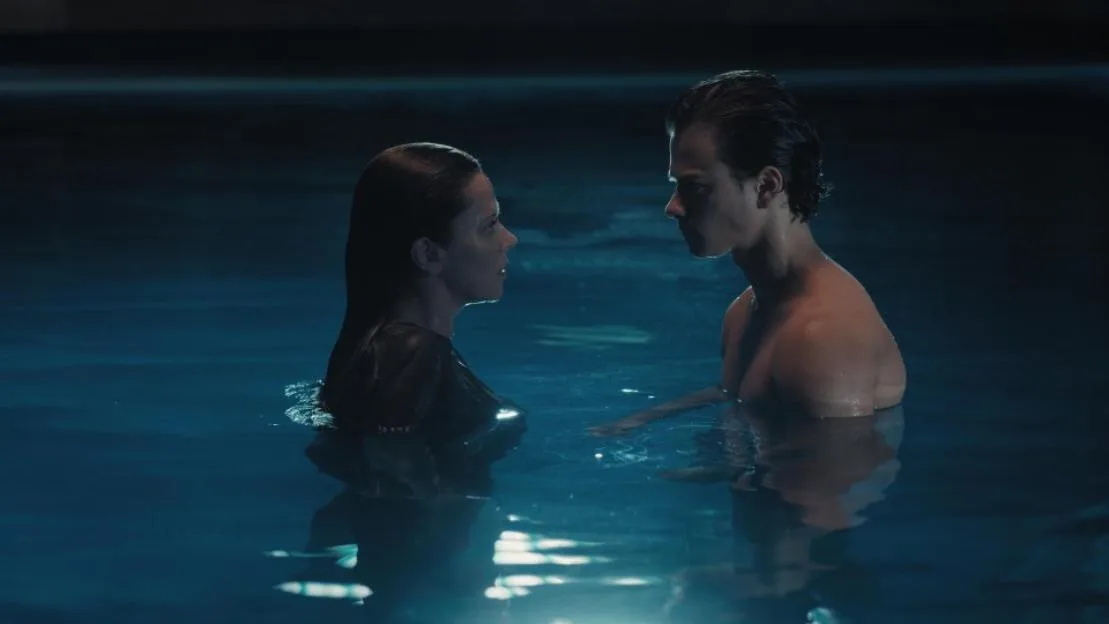 Ellen (Anna Friel) and Kieran (Conrad Khan) standing face-to-face in a pool at night.
