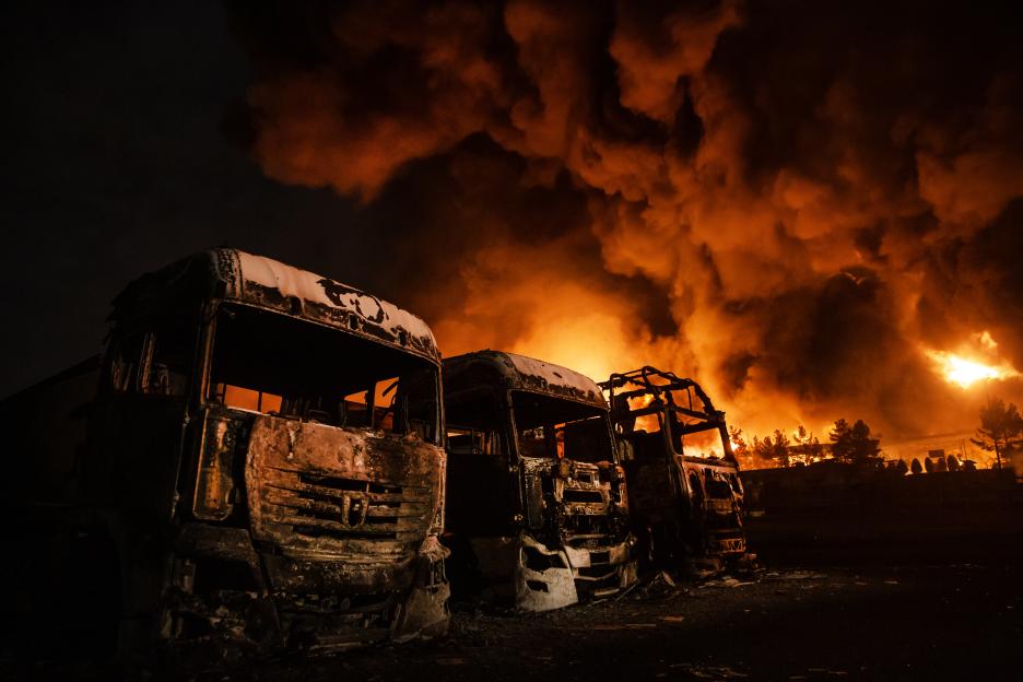 Burnt trucks and a large fire at the Shahran oil depot.