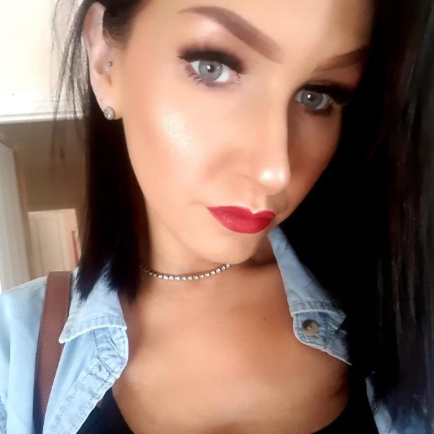 Rhian Stephens, mother of Lanie Williams, wearing a denim shirt, diamond choker necklace, and red lipstick.