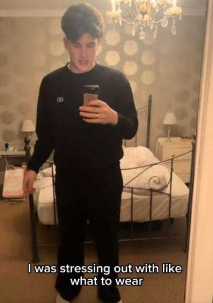 Joe Sandell filming himself in a full-length mirror, showcasing his outfit.