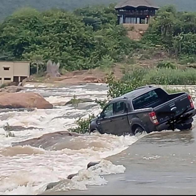 The swept away Ford Ranger of croc victim Gabriel Batista, 59, jammed on rocks just below the river bridge it had been swept off after floodwaters had subsided a little.
