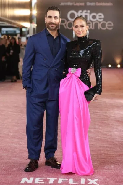 Brett Goldstein and Jennifer Lopez pose at the premiere of "Office Romance."